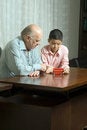 Free Grandfather And Grandson Are Sitting At The Table Royalty Free Stock Image - 5479096