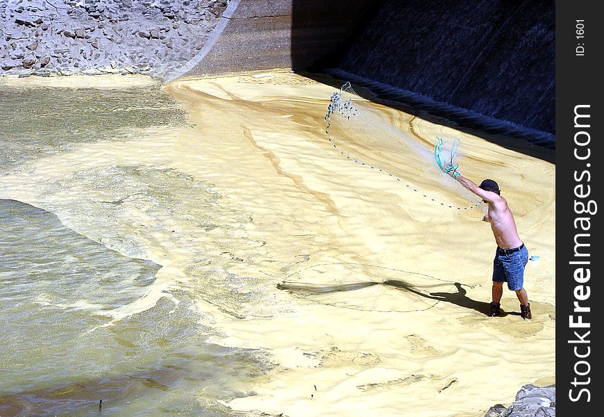 Lake Allatoona Georgia USA Man throwing fish net to catch bait fish the slime on the water is pine pollen. Lake Allatoona Georgia USA Man throwing fish net to catch bait fish the slime on the water is pine pollen