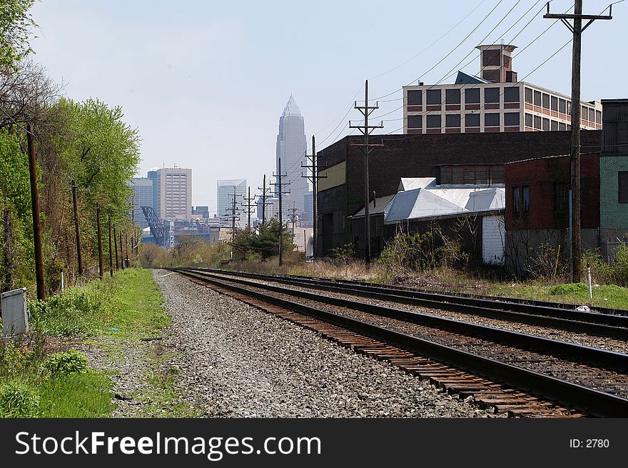 Rail Road tracks through an industrial area with buildings from downtown Cleveland, Ohio in the background. Rail Road tracks through an industrial area with buildings from downtown Cleveland, Ohio in the background