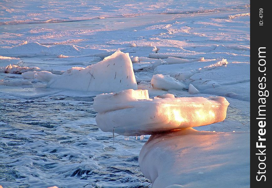 A large chunk of ice, in a frozen river. A large chunk of ice, in a frozen river