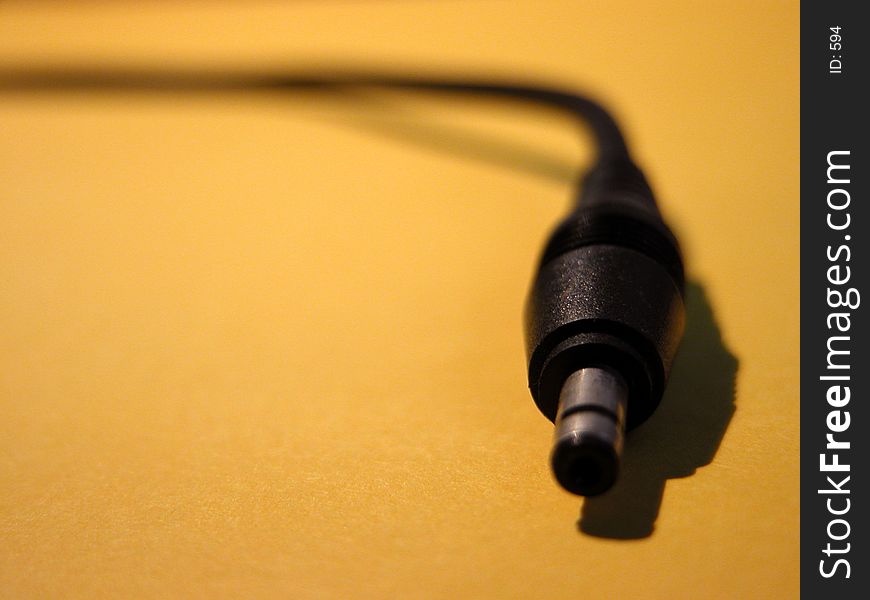 Closeup macro view of a cable with socket connector. Stretching from the top left to the right side of the image. Shallow depth of field with focus on socket. Closeup macro view of a cable with socket connector. Stretching from the top left to the right side of the image. Shallow depth of field with focus on socket.