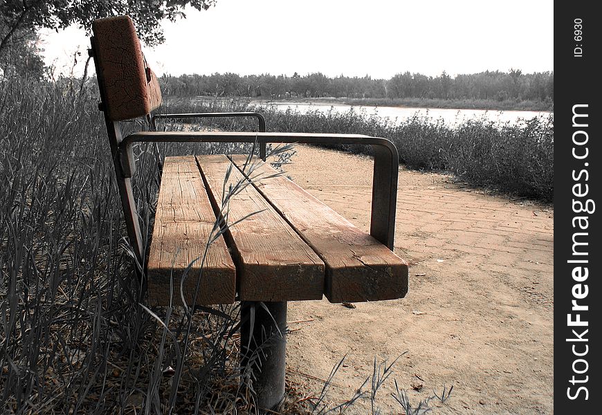 Bench sitting next to a gravel path, everything but sepia/brown tones desaturated. Bench sitting next to a gravel path, everything but sepia/brown tones desaturated.