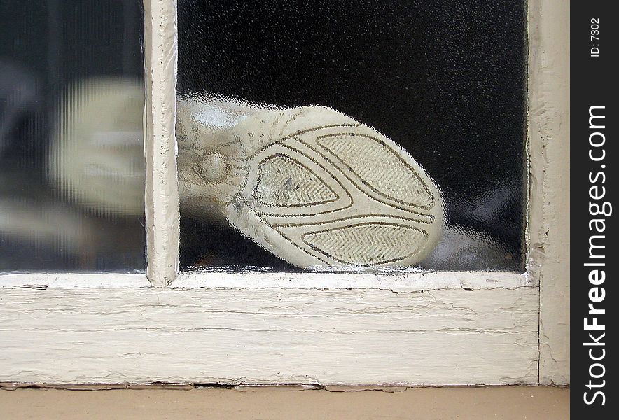 Sole of a sneaker, pressed up against a window. Sole of a sneaker, pressed up against a window.