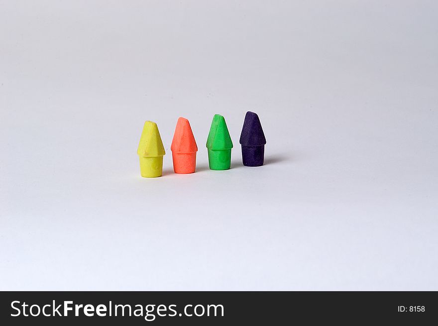 4 different colored pencil erasers arranged in a colorful row on a white background