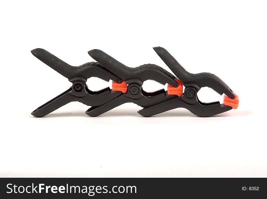 Three spring loaded clamps lined up and photographed on a white background. Three spring loaded clamps lined up and photographed on a white background