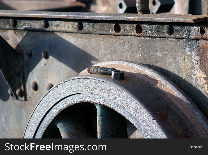 A discarded bolt lying on the wheel of a rusting steam engine chasis. A discarded bolt lying on the wheel of a rusting steam engine chasis.