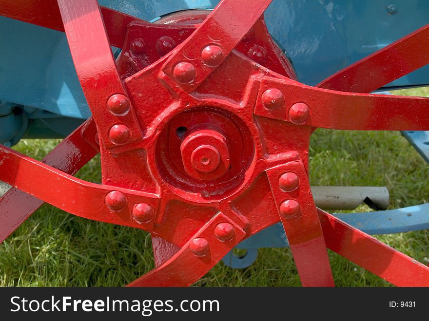 Dramatic colour shot of unusual metal spokes and hub of a restored old tractor. Dramatic colour shot of unusual metal spokes and hub of a restored old tractor