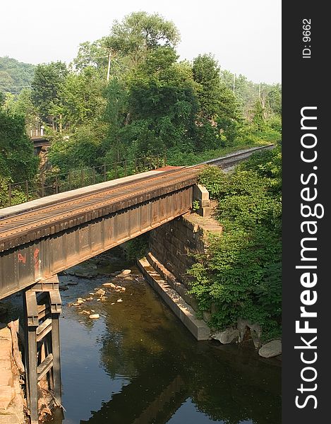 Verticle view of a train bridge crossing a small river