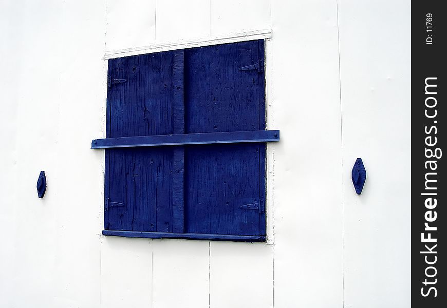 Blue Window on white building that is closed up! Abstract, exposed