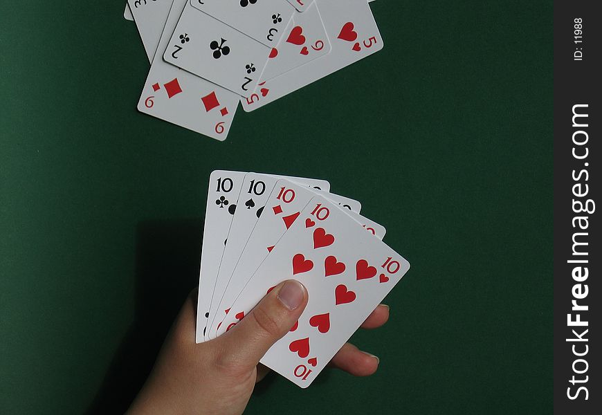 A hand with cards with green background. A hand with cards with green background.