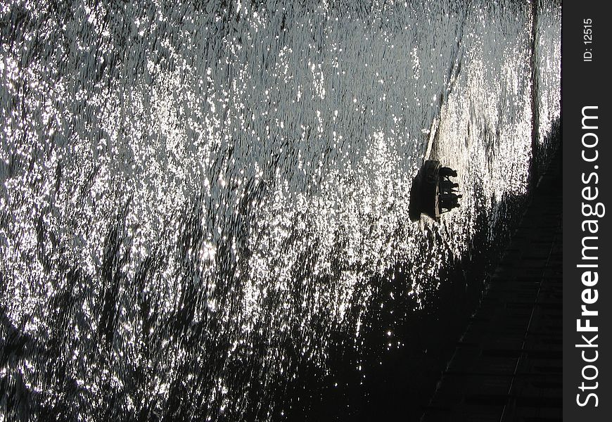 A small boat driving a loading canal in back light.