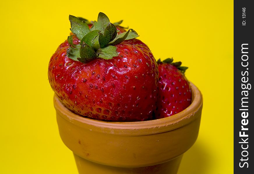 Photo of Strawberries in Pot on Yellow Background