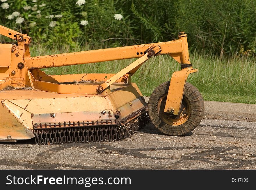 A large mowing attachment to a tractor commonly refered to as a brush hog in farming communities around the States.