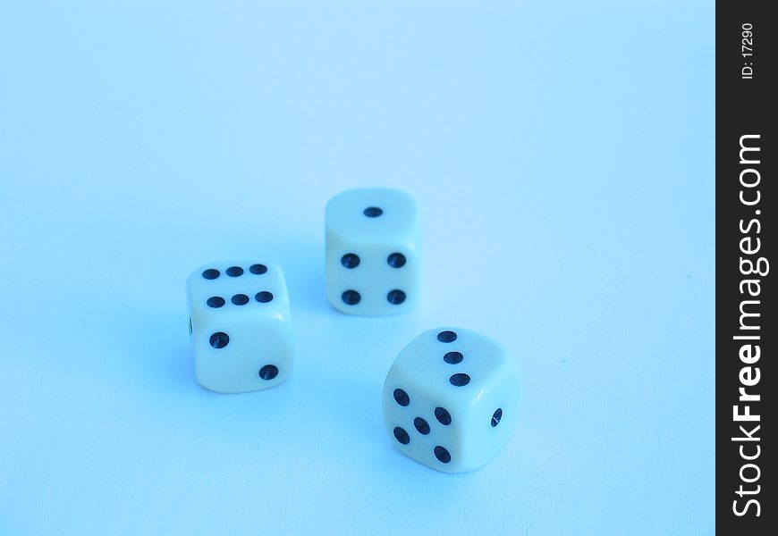 Three dice in blue shine.