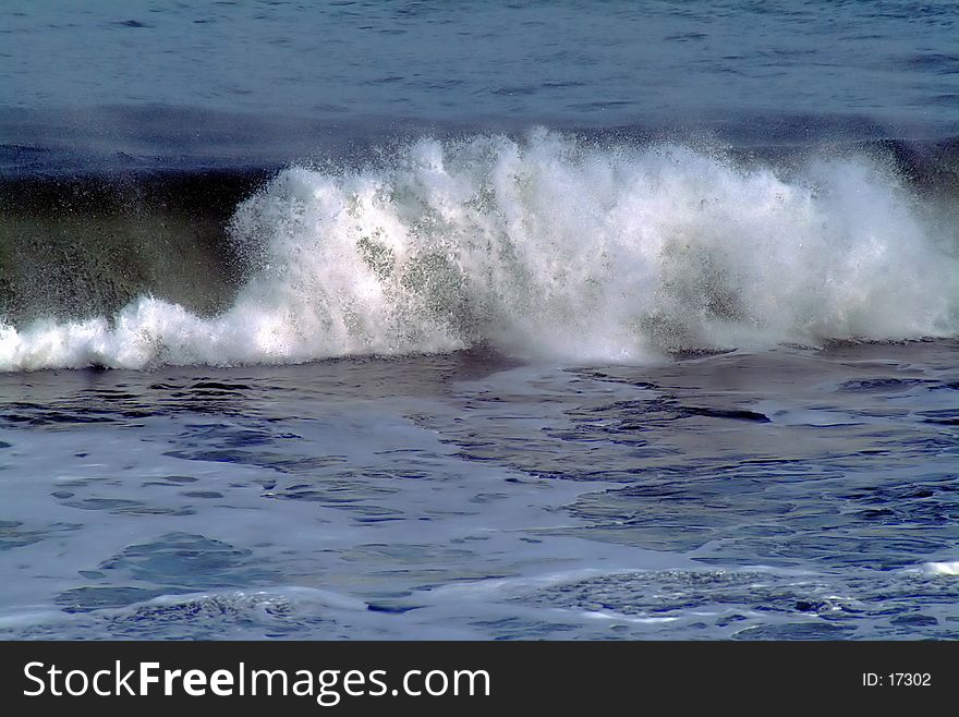 Wave crashing on shore, no horizon or location identification. Wave crashing on shore, no horizon or location identification