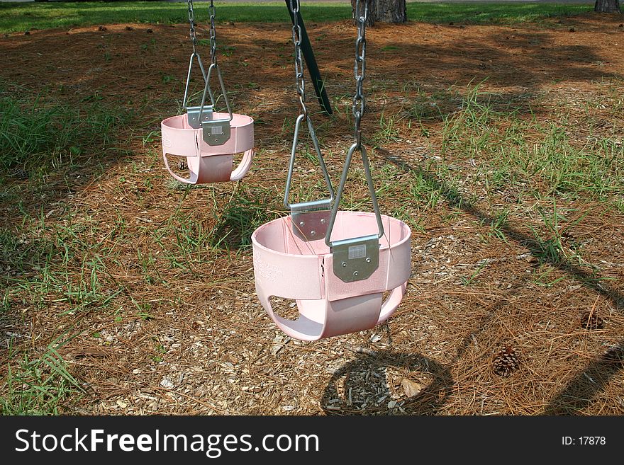 Pink baby swings in playground