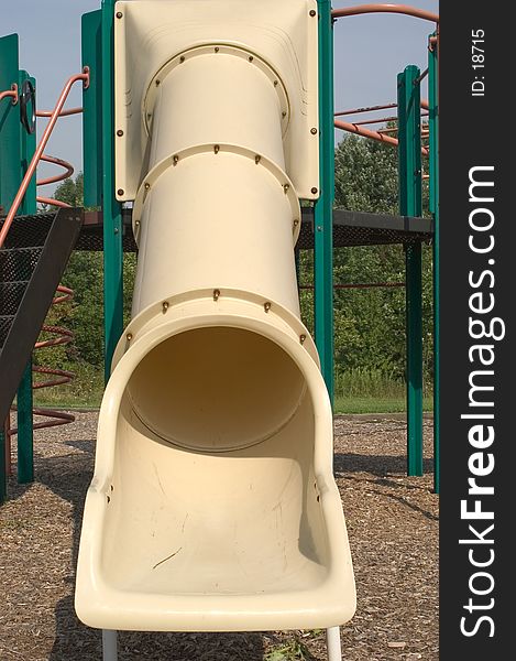 Childs slide in a playground made out of plastic tubes bolted together. Childs slide in a playground made out of plastic tubes bolted together.