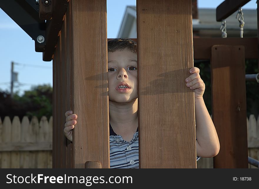 Photo of Child Looking From Behind Wooden Posts. Photo of Child Looking From Behind Wooden Posts.