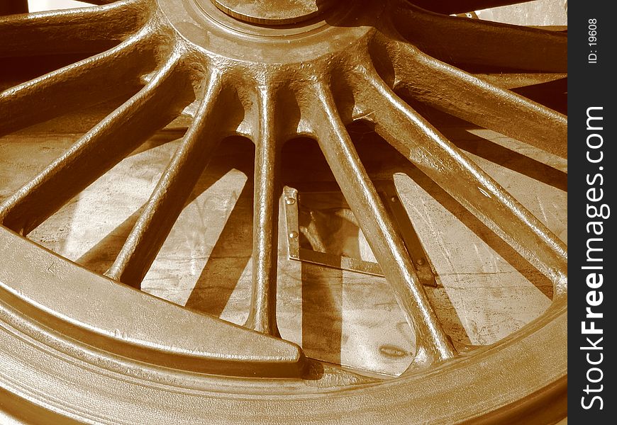 Historic locomotive wheel in sepia tone.