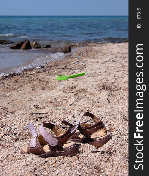 Kid's sandals abandoned on an empty beach. Kid's sandals abandoned on an empty beach.