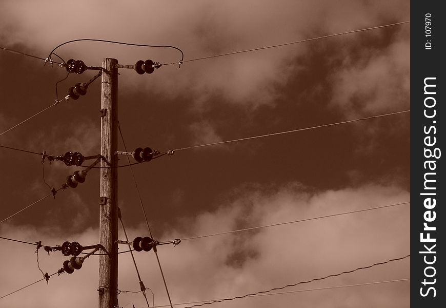 Sepia toned image showing powerlines/ phone lines, on wooden pole, high in the sky , holyoke, massachusetts. Sepia toned image showing powerlines/ phone lines, on wooden pole, high in the sky , holyoke, massachusetts