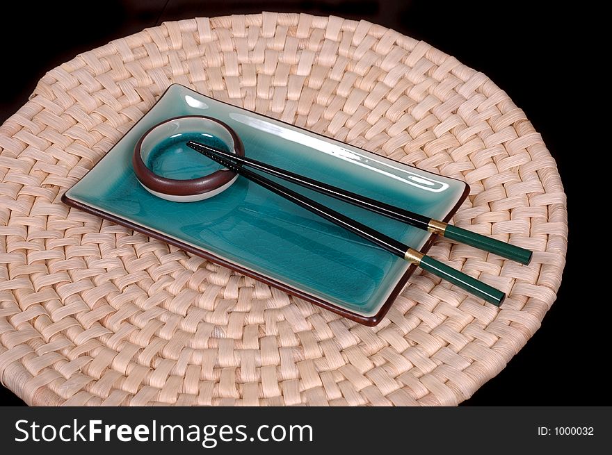 Blue plate, dipping bowl and chop sticks on mat