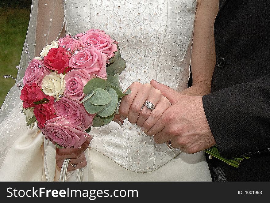 Bride holding bouquet and showing off wedding ring. Bride holding bouquet and showing off wedding ring