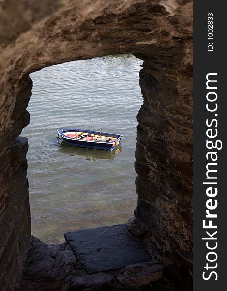 View of a small wooden row boat on the river dart looking through a stone walls window of bayards cove fort dartmouth devon england europe uk taken in july 2006