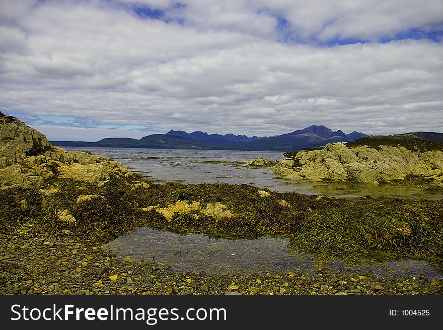 A scottish shore looking towards the cuillin mountains on scotland