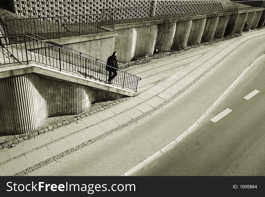 A street in denmark, shot from above (a bridge) ,a man going down the staircases. A street in denmark, shot from above (a bridge) ,a man going down the staircases