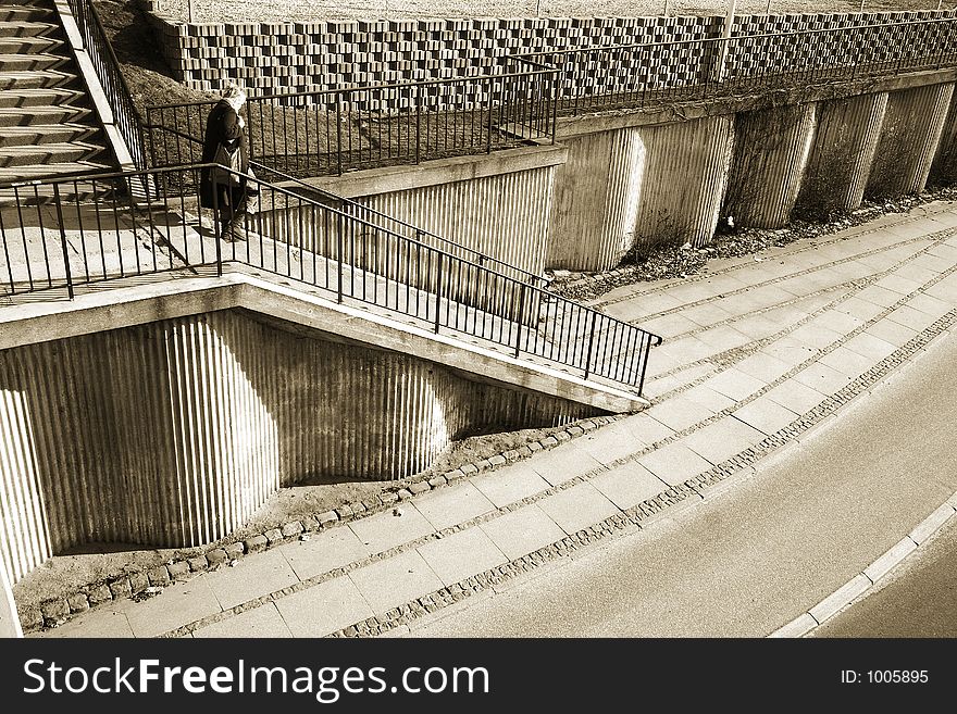 A street in denmark, shot from above (a bridge) ,a woman going down the staircases. A street in denmark, shot from above (a bridge) ,a woman going down the staircases