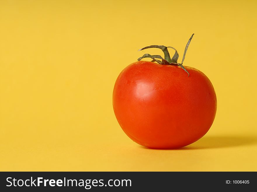 Tomato on yellow background