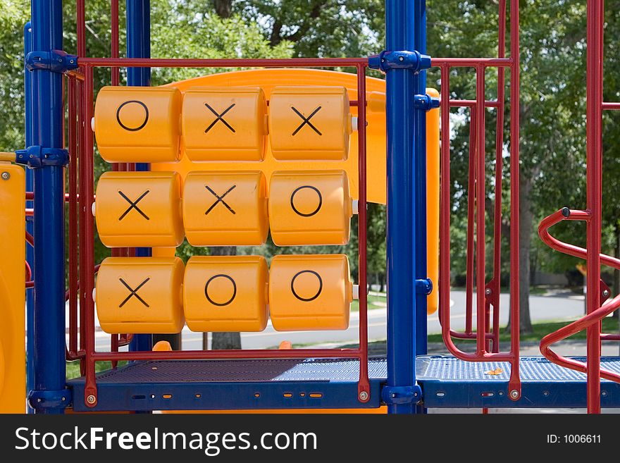 A tic tac toe game in bright primary colors graces a public park where children play and learn to compete and imagine. A tic tac toe game in bright primary colors graces a public park where children play and learn to compete and imagine.