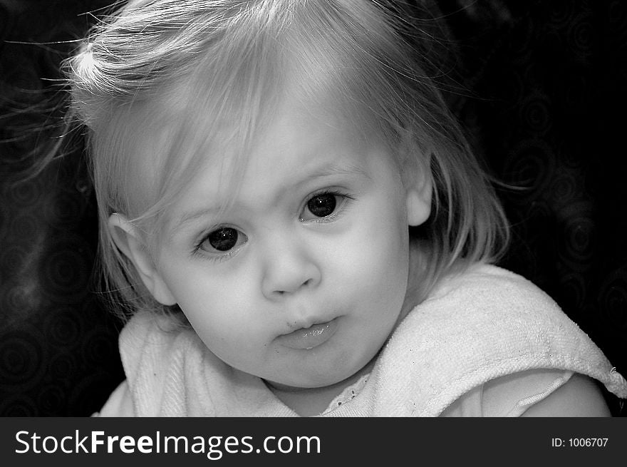 A baby with a serious expression on her face.