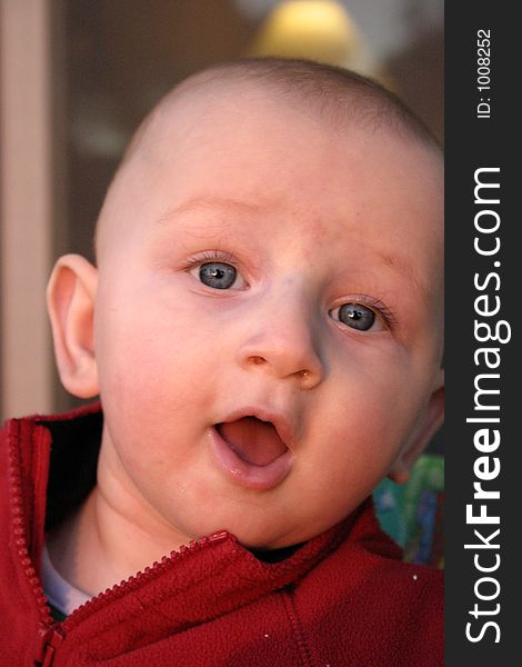 Infant boy in red sweater looking surprised. Infant boy in red sweater looking surprised