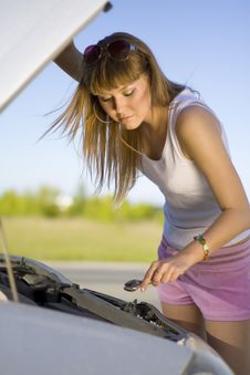 Girl Looking Under The Car Royalty Free Stock Image