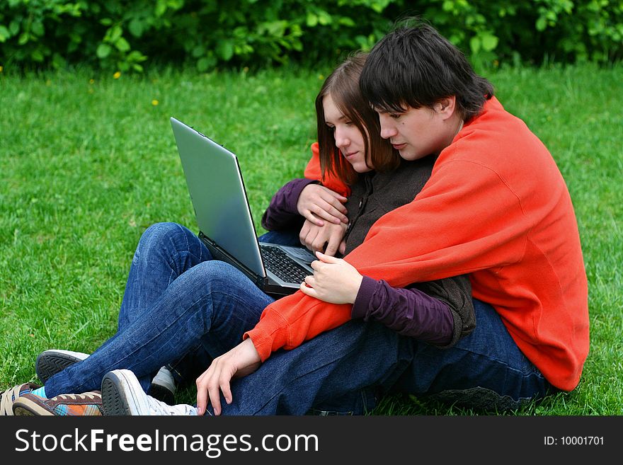 couple on grass with laptop computer