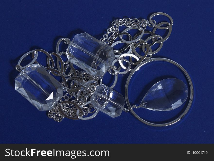 Costume jewellery of silvery color on dark blue background