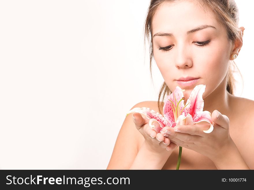 Beautiful young woman contemplating a flower