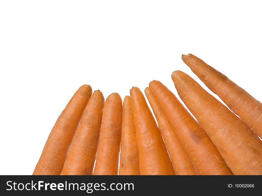 Ripe fresh carrots placed in the corner of the picture isolated on white background