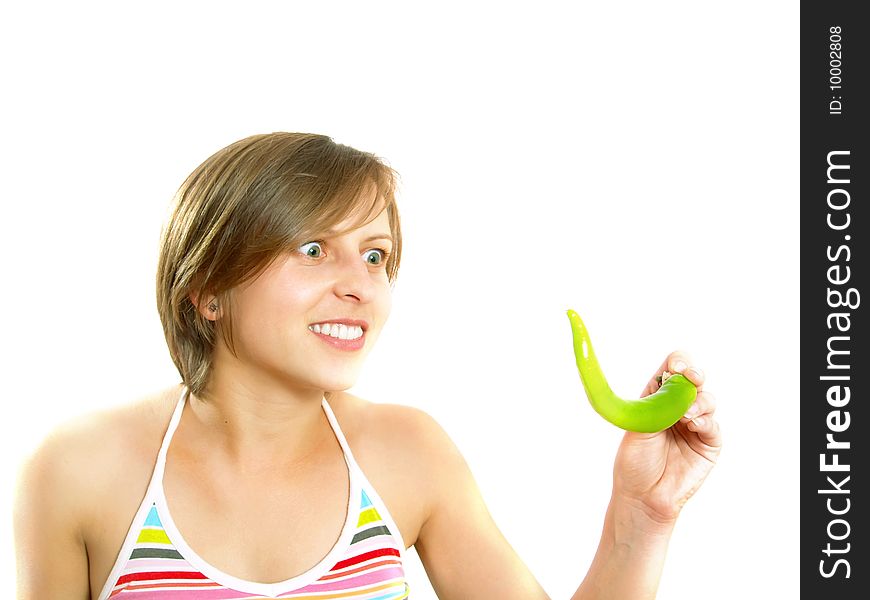 Portrait of a young cute Caucasian blond lady with a nice colorful striped summer dress who is going crazy and she is holding a fresh green chilly pepper in her hand. Isolated on white. Portrait of a young cute Caucasian blond lady with a nice colorful striped summer dress who is going crazy and she is holding a fresh green chilly pepper in her hand. Isolated on white.