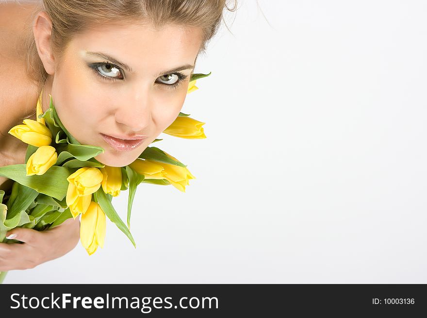 Close-up fresh blonde lady with beautiful make-up with tulips. Close-up fresh blonde lady with beautiful make-up with tulips