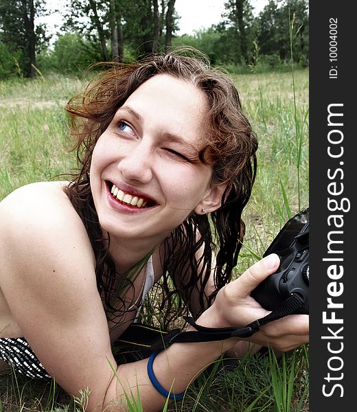 Girl smiling and up one's eyes with photo camera. Girl smiling and up one's eyes with photo camera