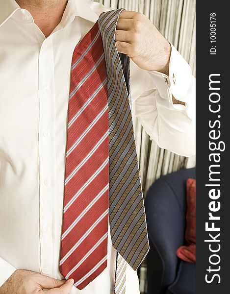 Handsome young businessman adjusting tie