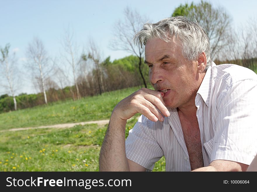 Pensive mature man resting outdoor in summer. Pensive mature man resting outdoor in summer