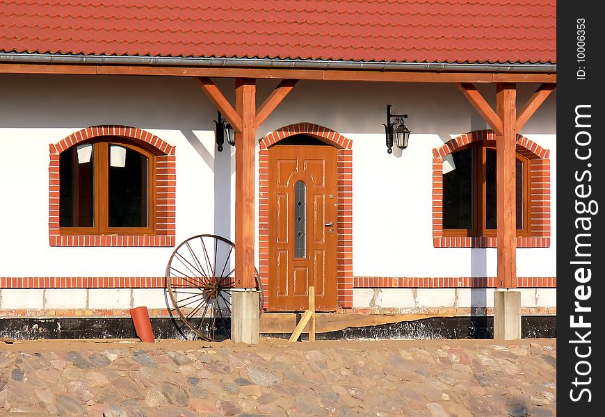 Close up of the front of the new farmhouse. View of the door to the new house in the countryside. Close up of the front of the new farmhouse. View of the door to the new house in the countryside.