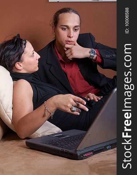 Young couple on the couch surfing the web with their laptop. Young couple on the couch surfing the web with their laptop.