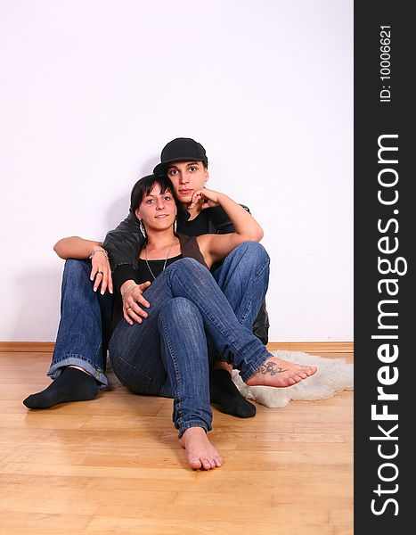 Young couple in hiphop / emo style sitting on the floor barefeet.