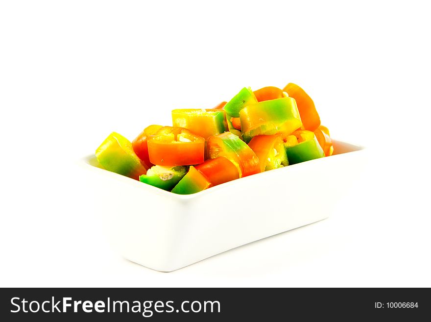 Red, yellow and green chillis chopped in a dish with clipping path on a white background. Red, yellow and green chillis chopped in a dish with clipping path on a white background