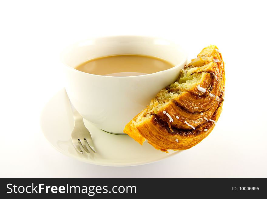 Half a cinnamon bun with a cup of tea and fork with clipping path on a white background. Half a cinnamon bun with a cup of tea and fork with clipping path on a white background